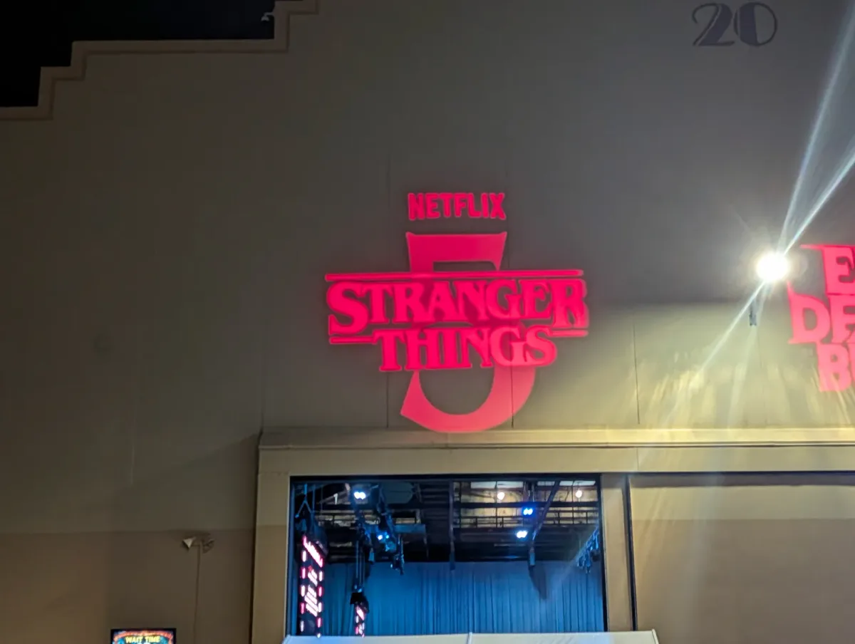 The Stranger Things 5 logo projected in red above the entrance to the haunted house's soundstage